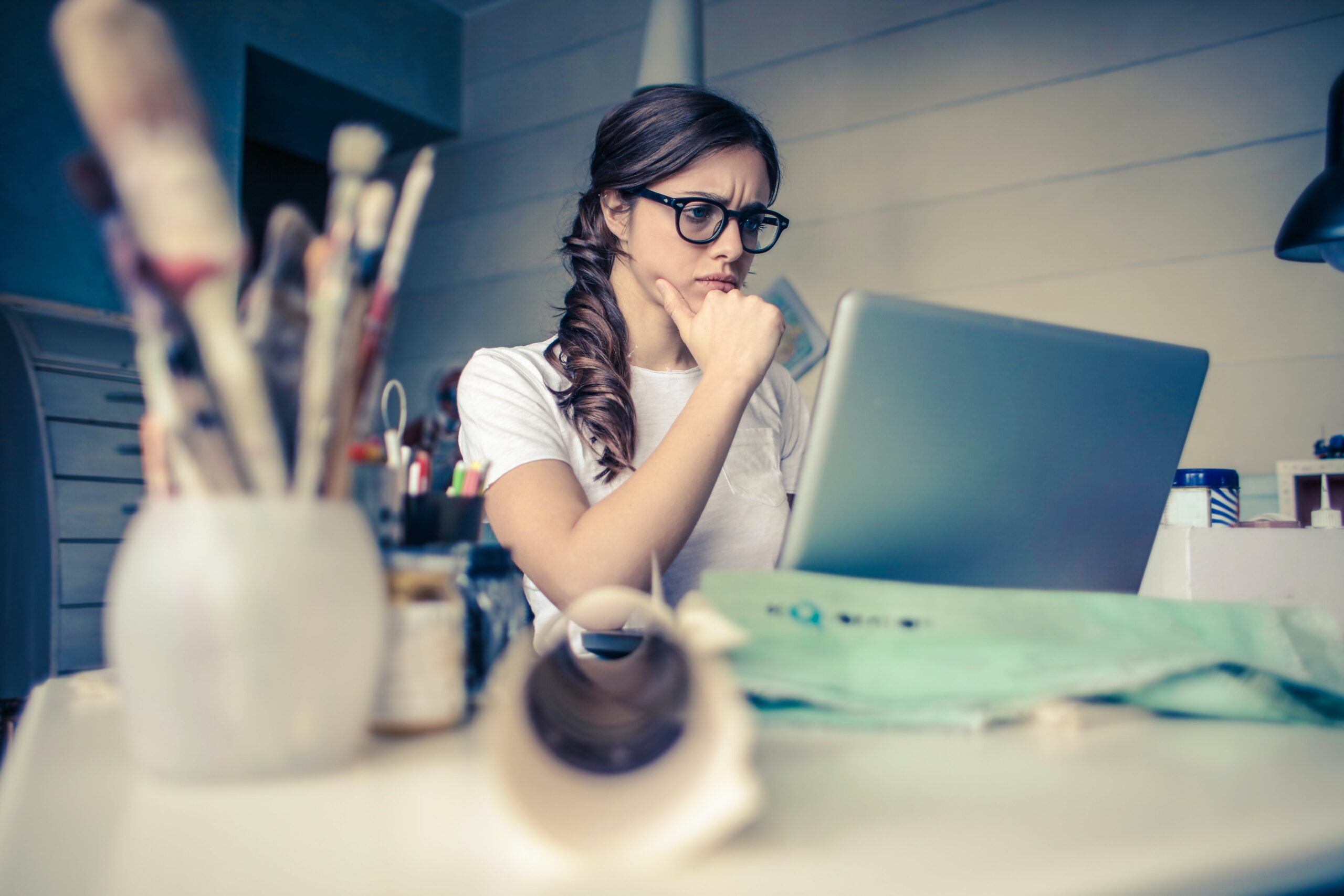 Woman thinking while looking at a computer screen