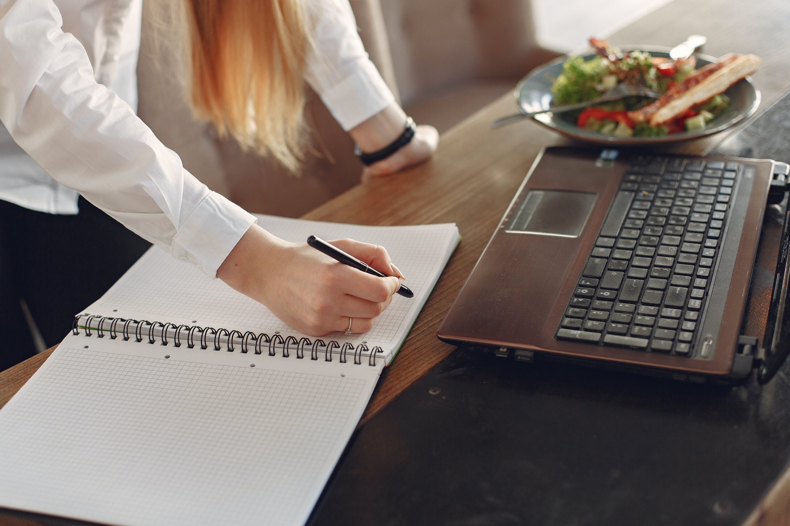 Woman writing in planner on desk