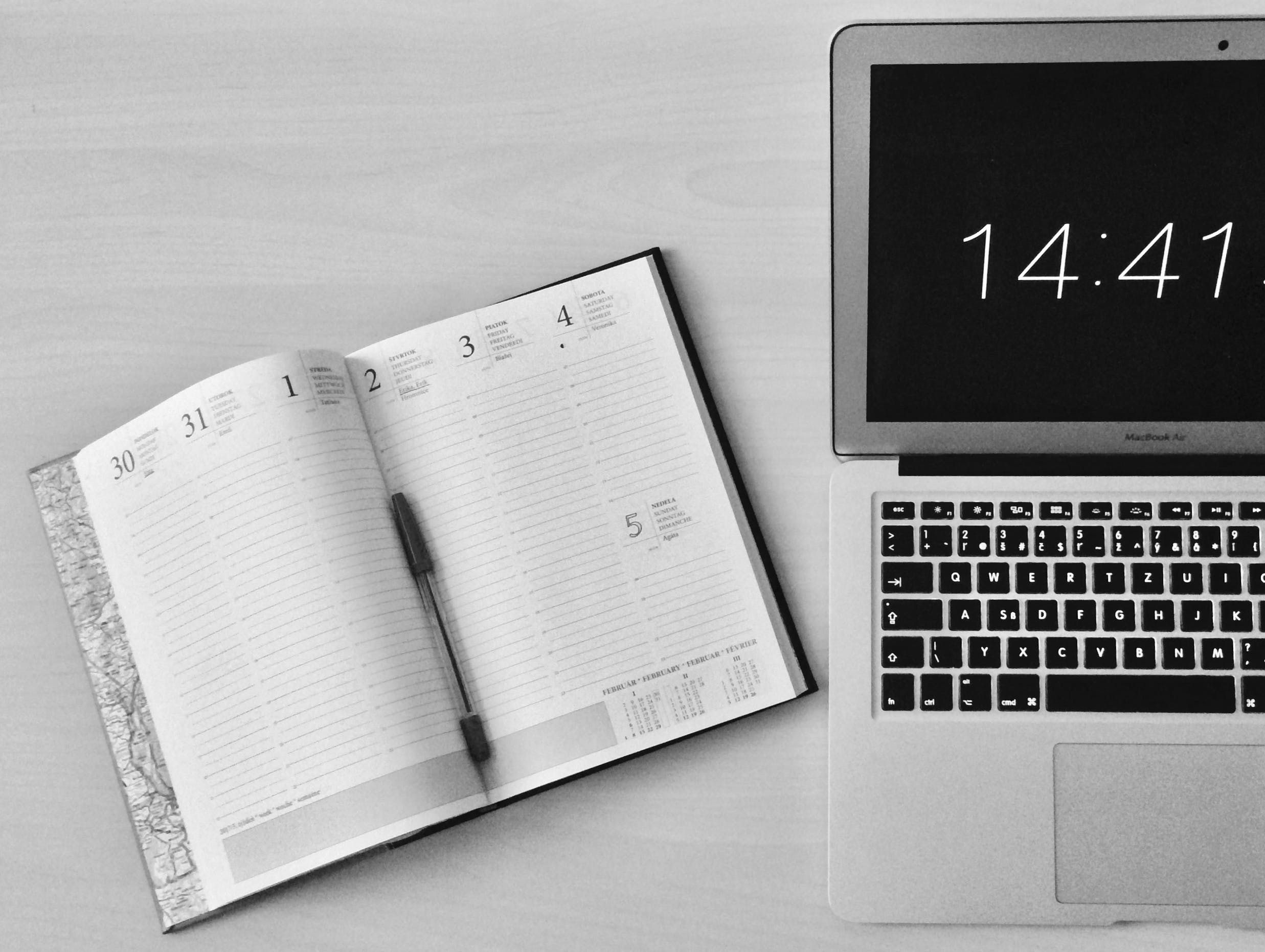 Planner beside a laptop with the time on it